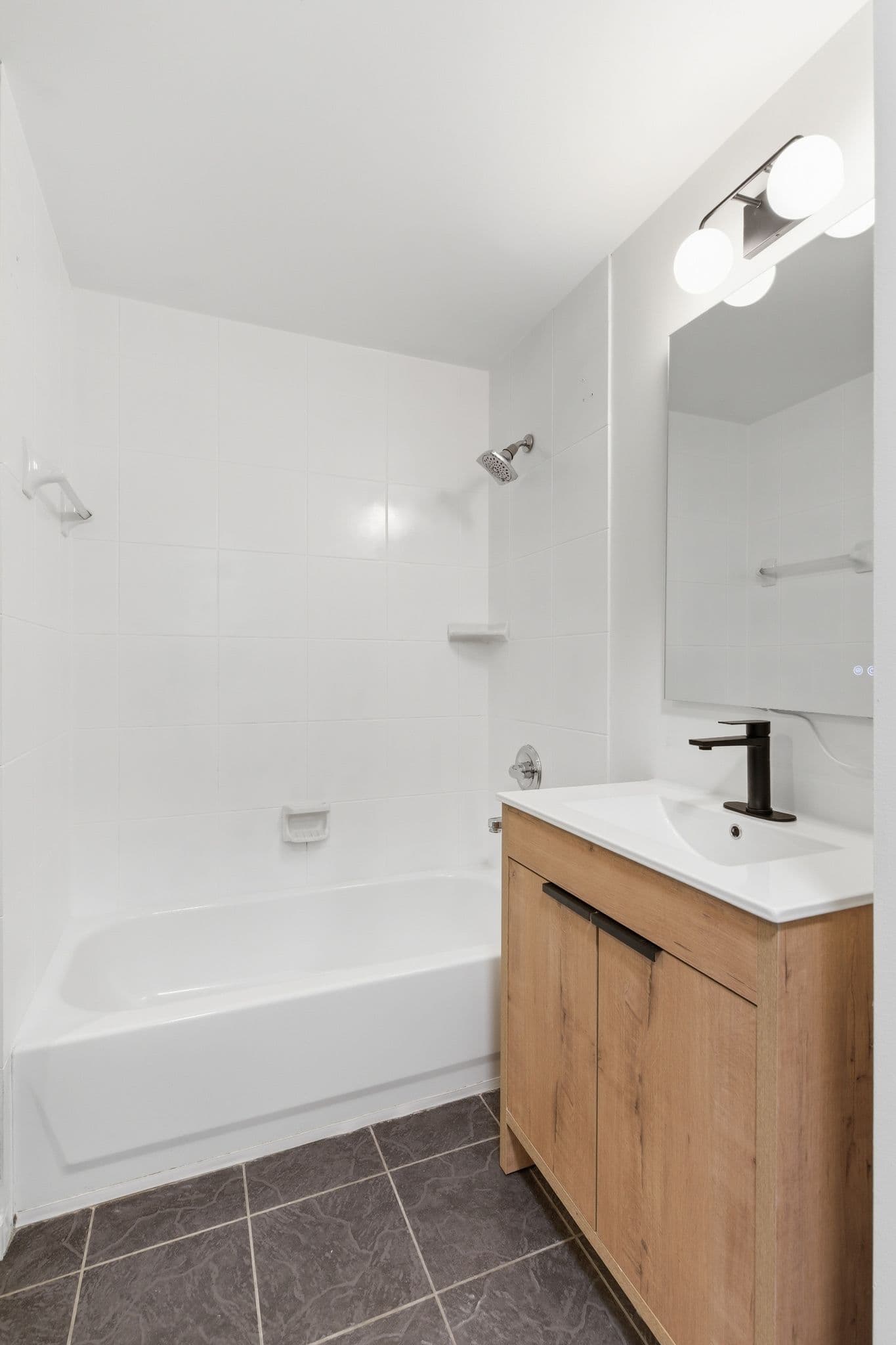 Bathroom with painted walls, shower tile, and wood vanity by Walsh Painting Nashville