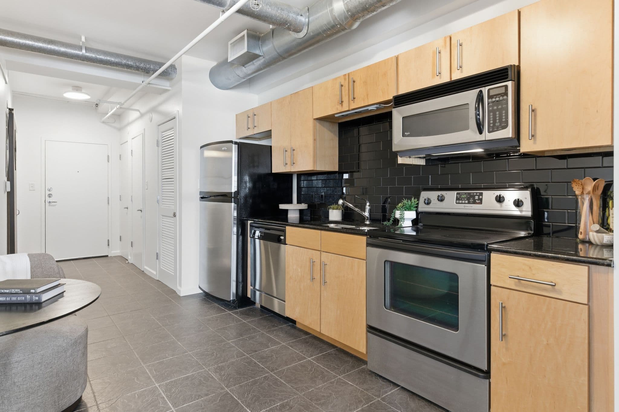 Galley-style kitchen with maple cabinets and clean painted walls in a Nashville loft