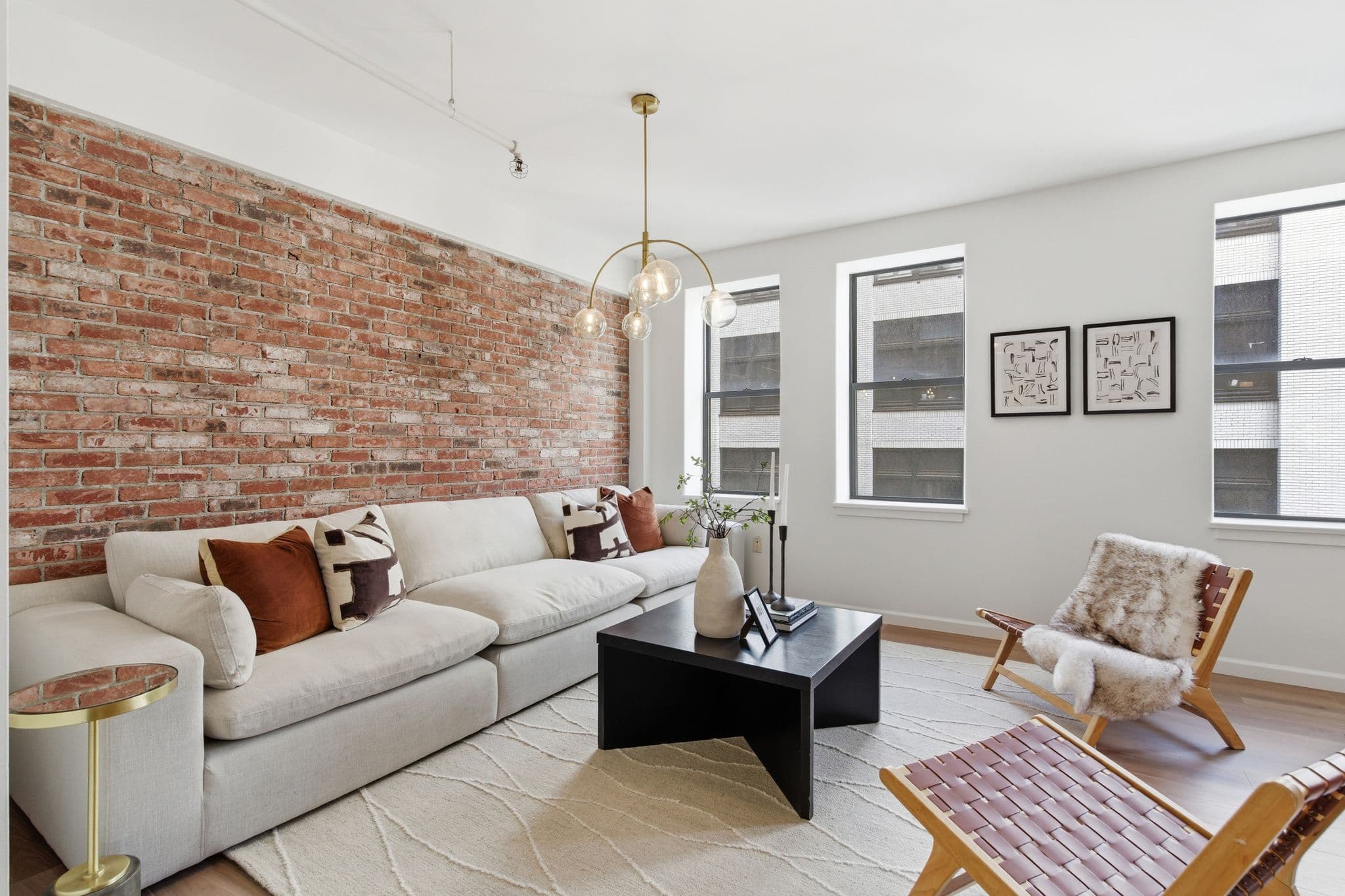 Modern loft living room with crisp painted walls and exposed brick accent, Nashville
