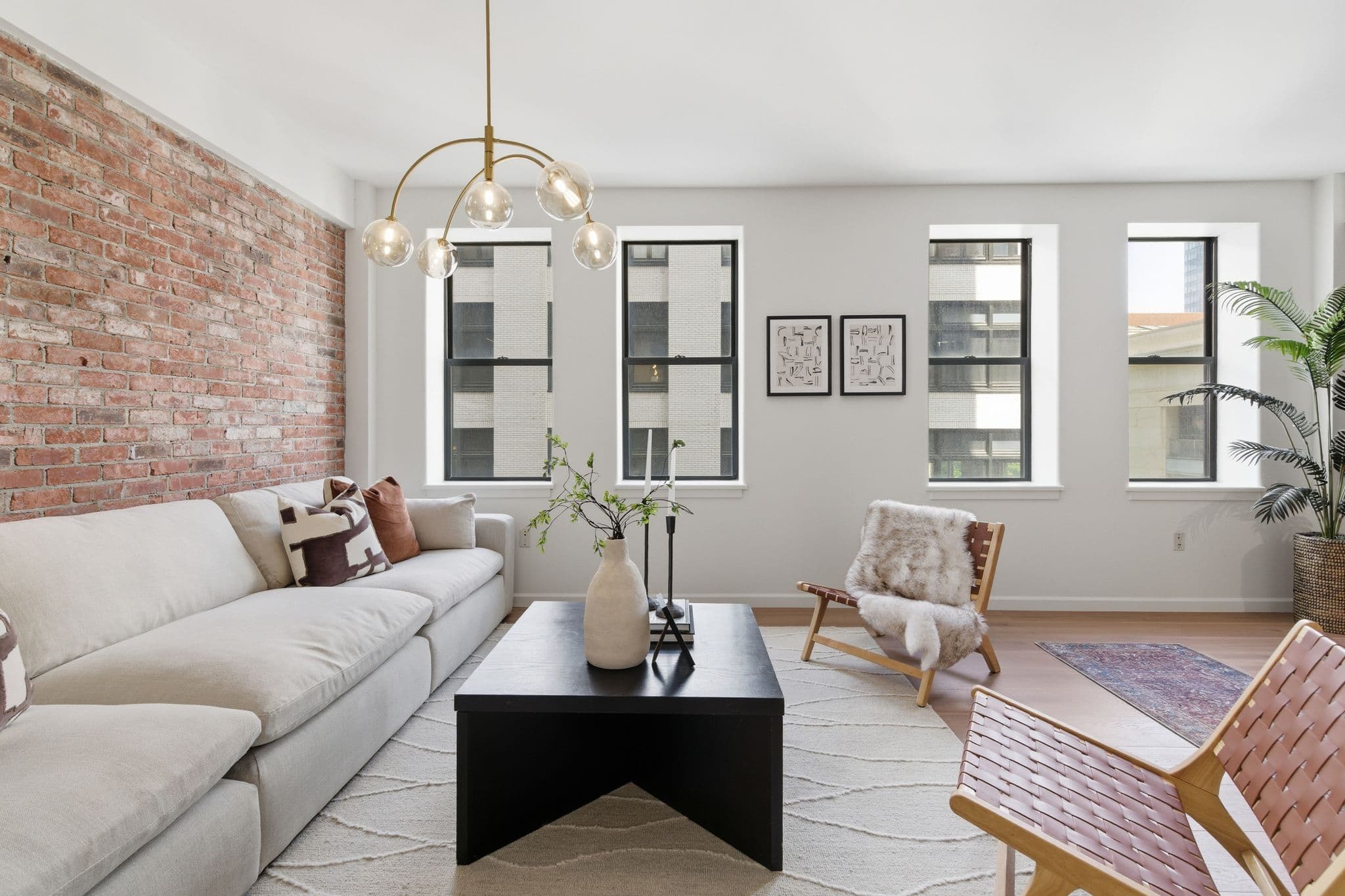 Open-concept downtown Nashville loft living room painted in soft white with a chandelier and large windows by Walsh Painting