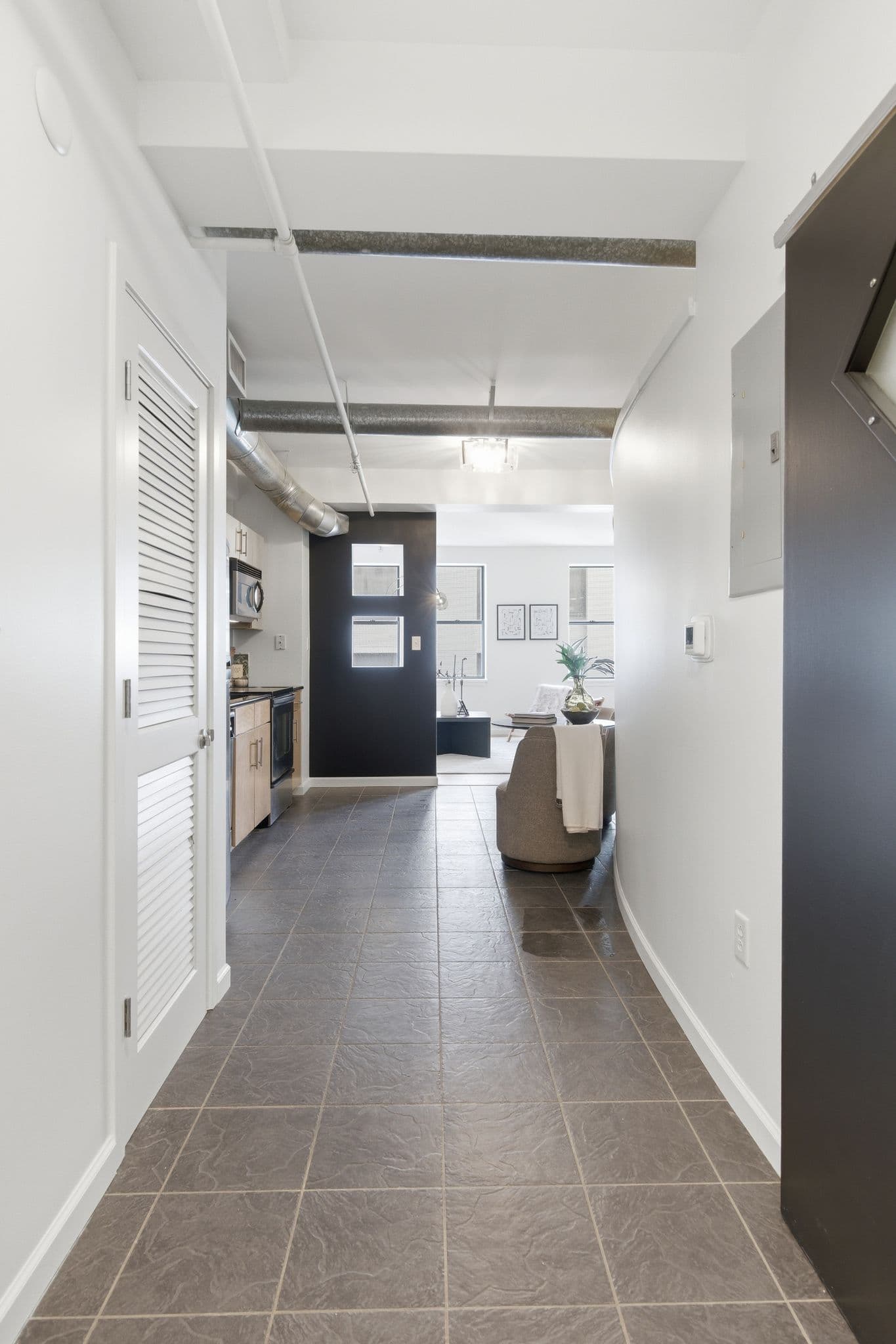 Loft hallway looking toward kitchen with painted white walls and ceilings, Nashville
